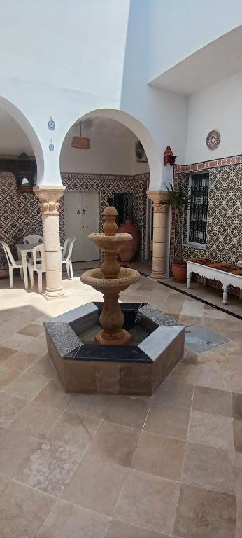 a fountain in the middle of a room at Dar HJAIJA in Hammamet