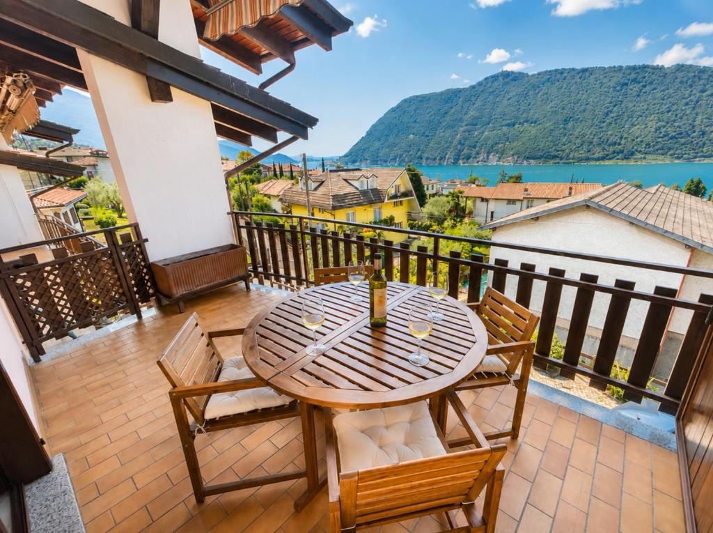 a table and chairs on a balcony with a view at Dolce Vita LakeView - By Turidea in Sale Marasino