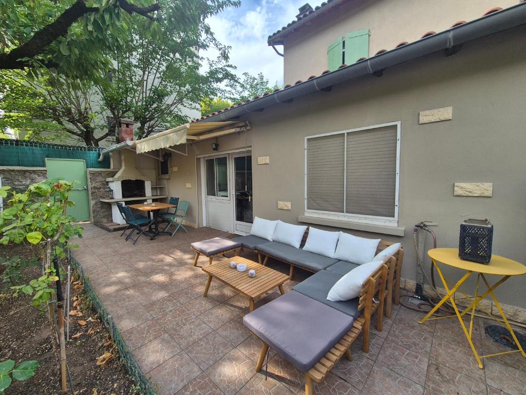 a patio with a couch and a table at L'Ostal De Papi in Saint-Affrique