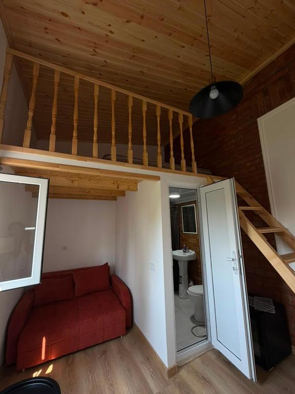 a living room with a red couch and a loft at Giorgi in Poti