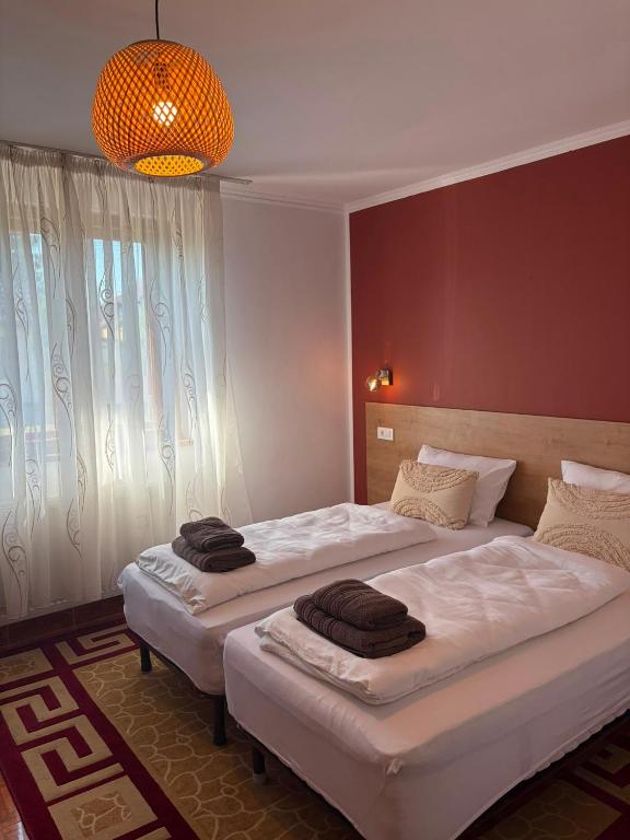 a bedroom with two beds with towels on them at La umbra nucului bătrân in Ghimbav