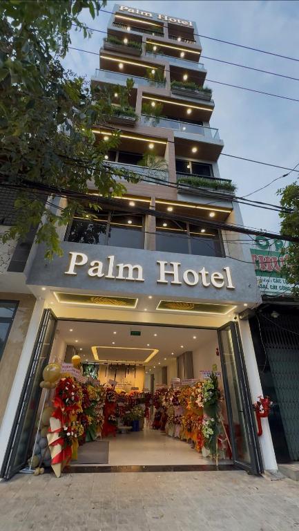 a store front of a paliman hotel with flowers in it at Palm Hotel in Tam Kỳ