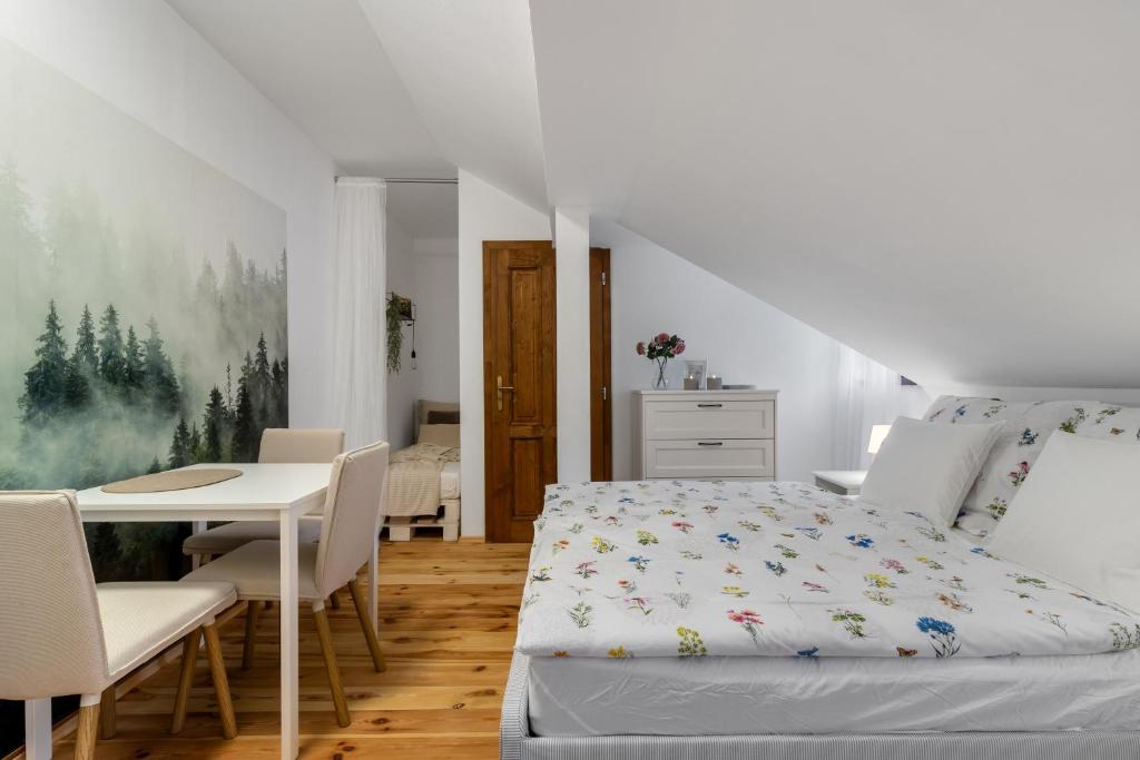 a bedroom with a bed and a table and chairs at Apartmán TICHO - Ostrůvek in Lesná