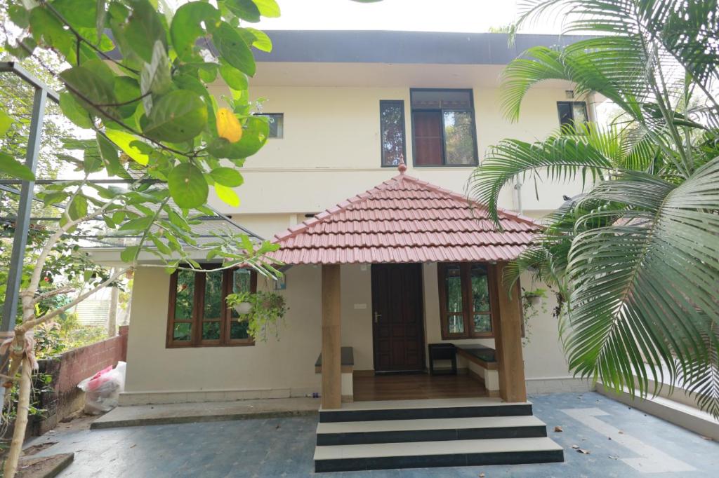 a small house with a red roof at SITER Holidays Villa in Kovalam