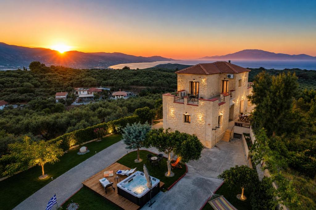 an aerial view of a house with the sunset in the background at Casa Adam and spa in Zakynthos