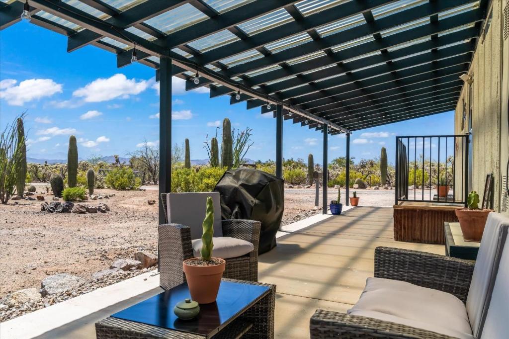 an outdoor patio with wicker furniture and a pergola at Cozy Desert Hideaway in Tucson