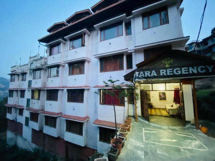 a large white building with a sign on it at Tara Regency Hotel in Shimla