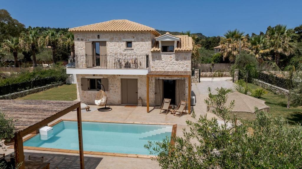 a villa with a swimming pool and a house at Casa Falco in Vasilikos