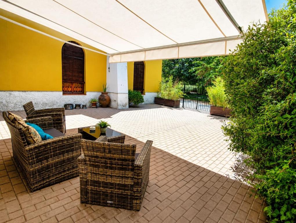 an outdoor patio with wicker chairs and a table at Aromas del Raposo in Puebla de Sancho Pérez