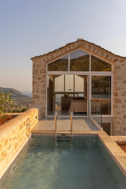 a house with a swimming pool in front of a building at Eks Mani Peninsula Retreat in Pirgos