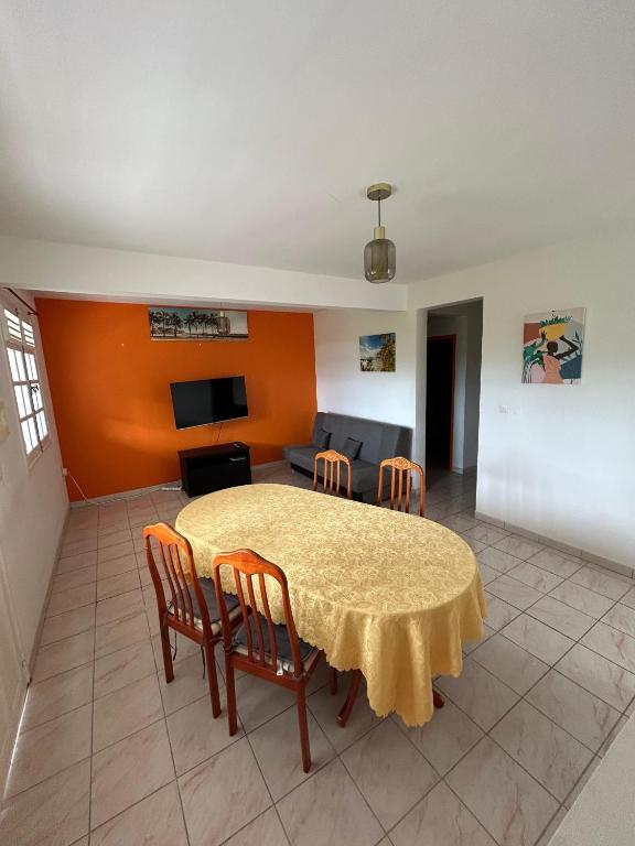 a living room with a table and chairs and a couch at Tropical Orange House in Ducos