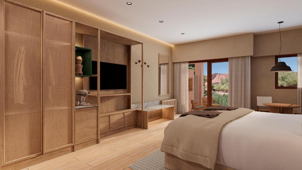 a bedroom with a large bed and a television at Nayara Alto Atacama in San Pedro de Atacama
