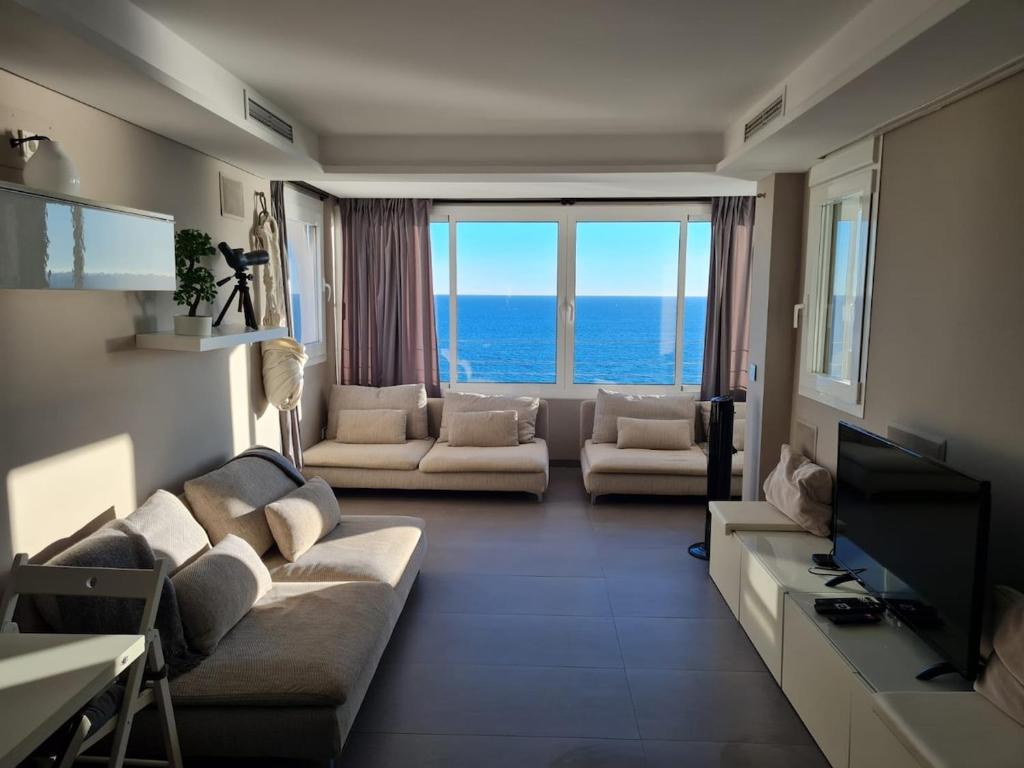 a living room with two couches and a television at Romantische Auszeit Penthouse mit Meerblick in Sitio de Calahonda