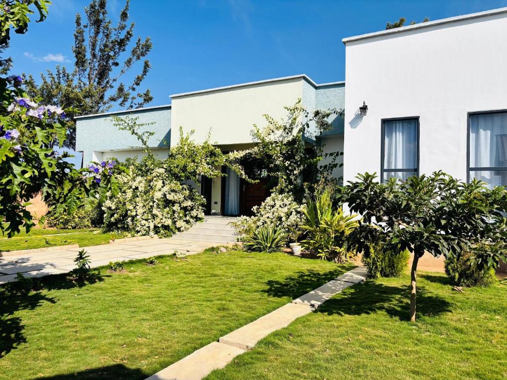 ein Haus mit einem Garten davor in der Unterkunft Bougainvillea House in Mwaja