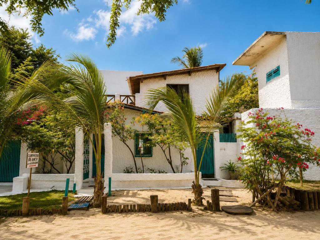 a house with palm trees in front of it at Residencial dos Freitas in Jericoacoara