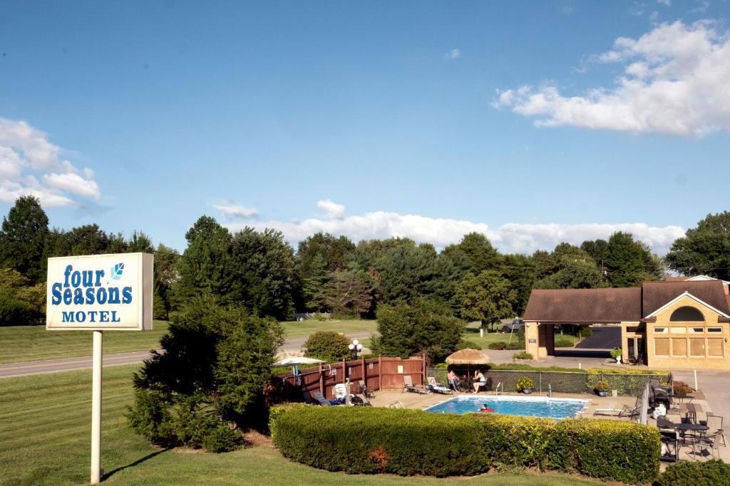 a sign for a resort with a pool and a building at Four Seasons Lodging in Mount Vernon