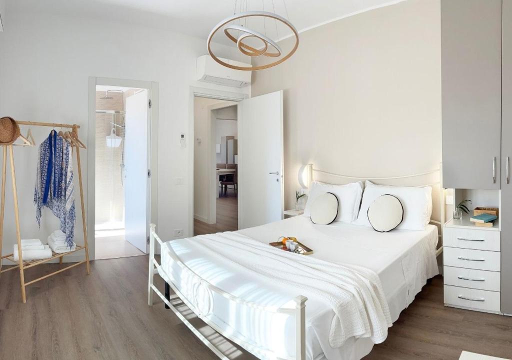 a white bedroom with a white bed and a mirror at Holihome - LUNA in Tortoreto Lido