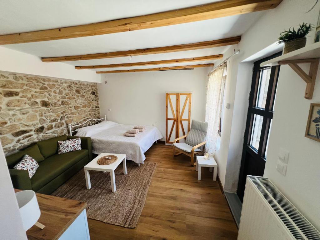 a living room with a bed and a couch at Nevoliani stone house in Florina