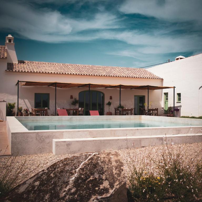 a villa with a swimming pool in front of a house at Casas do Seixo - Monsaraz in Cabeça de Carneiro