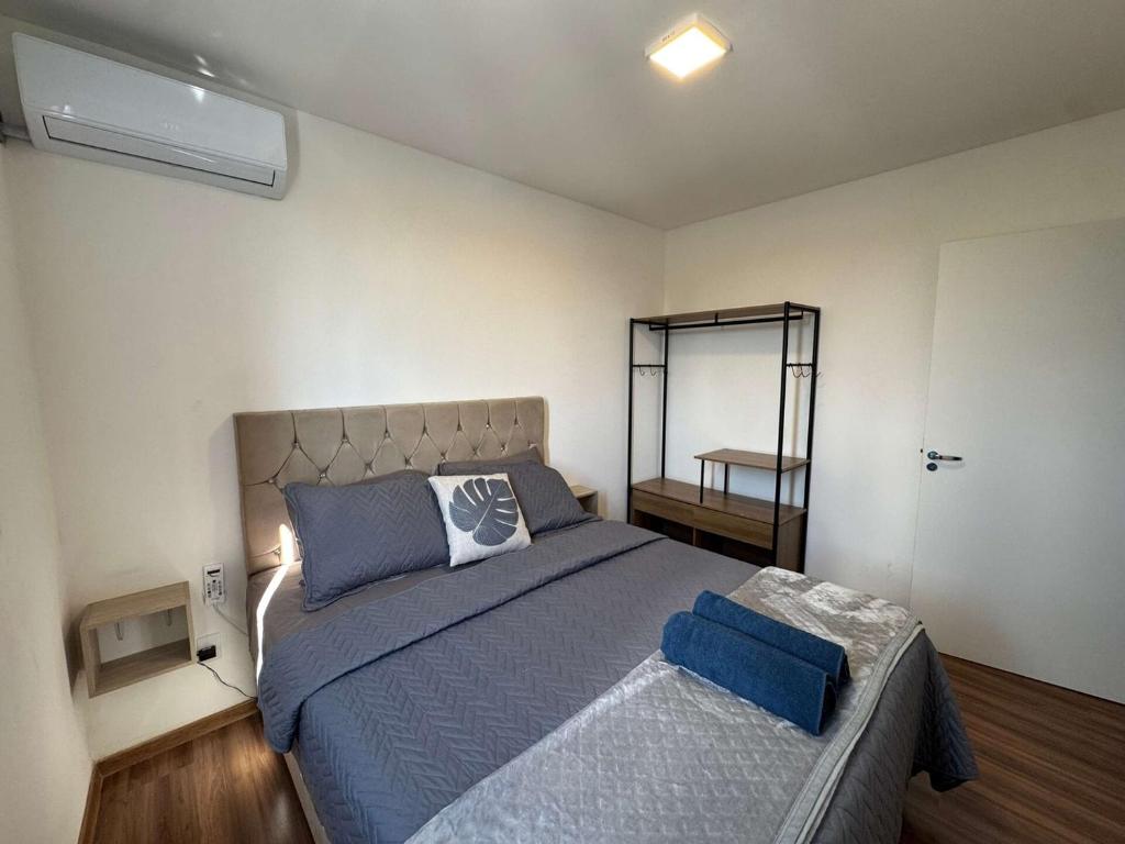 a bedroom with a large bed and a mirror at Edifício Forte dos Lagos in Toledo
