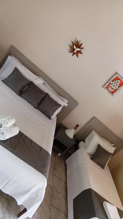 a bedroom with a bed with white sheets and pillows at Pousada Aquarela de Itaunas in Conceição da Barra
