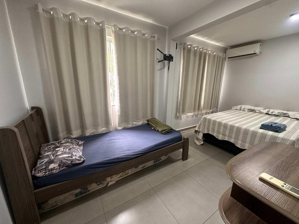 a small bedroom with a bed and a window at Ape do lado do ginasio lago faculdades e mercados in Toledo