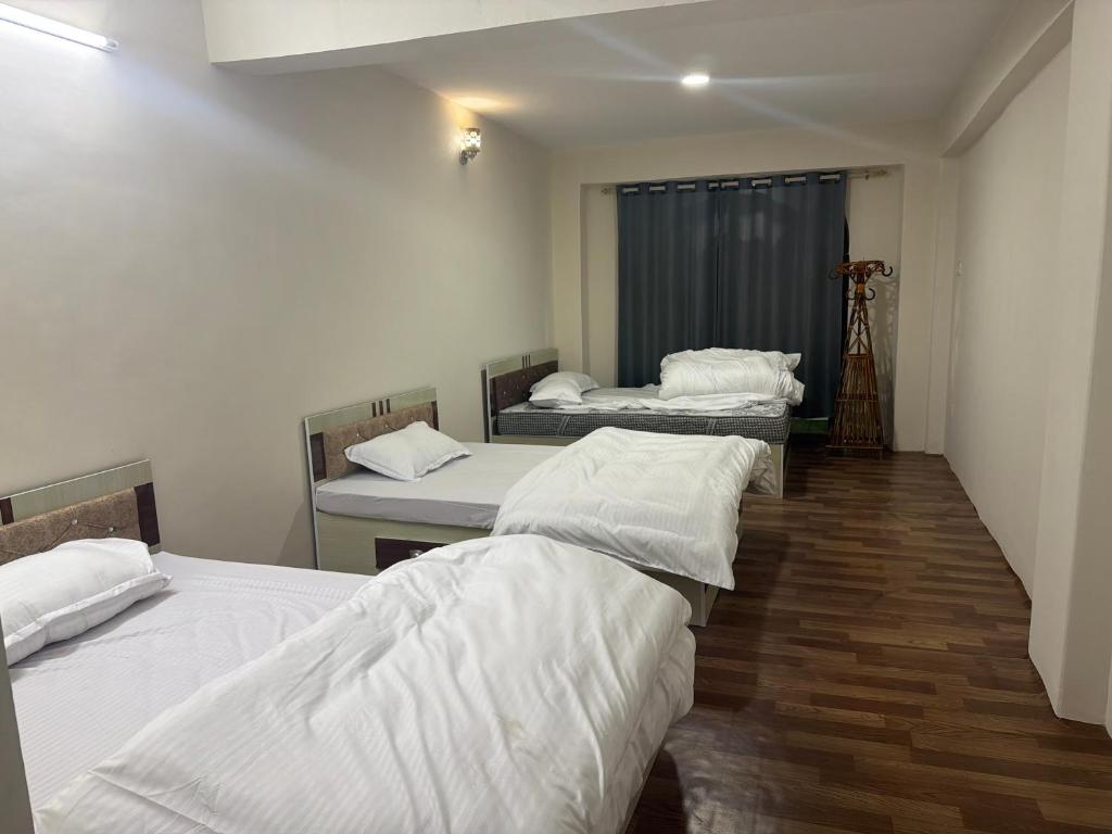 a group of three beds in a room at Double tree 2 in Burhānilkantha