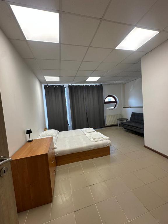 a hospital room with a bed and a couch at APARTMÁN CENTRUM Palackého in Trenčín