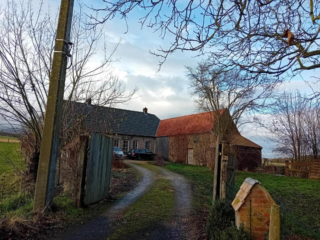 a dirt road next to a barn and a house at Kamer in Fermette Vlaamse Ardennen in Maarkedal