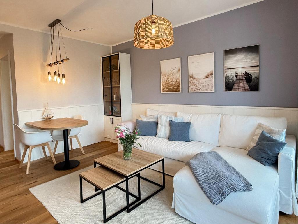 a living room with a white couch and a table at Ferienwohnung Seeperle am Dümmer See in Lembruch