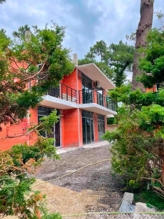 an orange house with a balcony and trees at Blue Horizon in Grigoleti