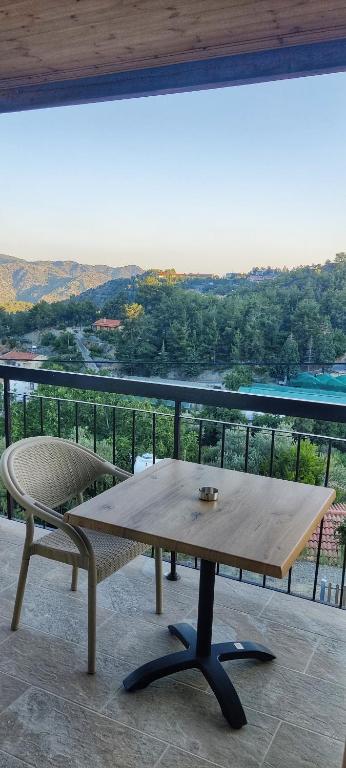 a wooden table and a bench on a balcony at PetroLithos Traditional Suites in Agros