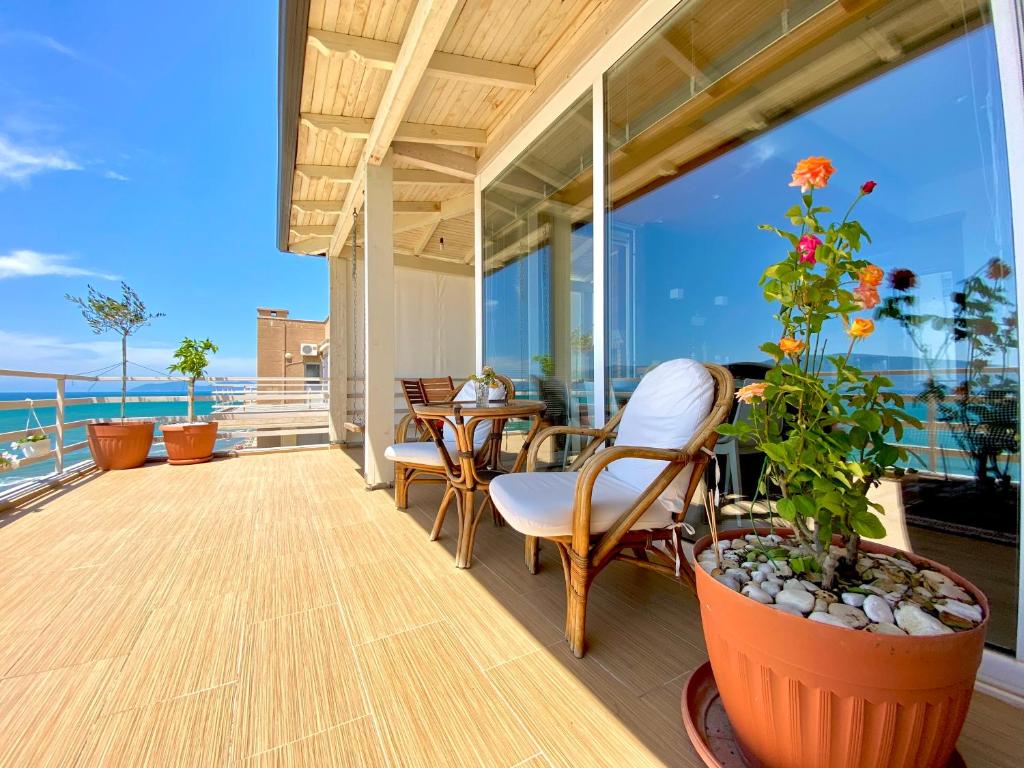 a balcony with a table and chairs and a view of the ocean at EKA Luxury Beachfront Apartments in Vlorë