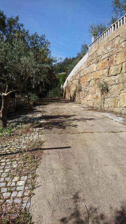an empty road next to a stone wall at Chez Isabelle chambre simple in Magrelos