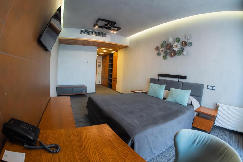 ein Schlafzimmer mit Bett, Fernseher und Tisch in der Unterkunft MOJO HALL Hotel in Luzk