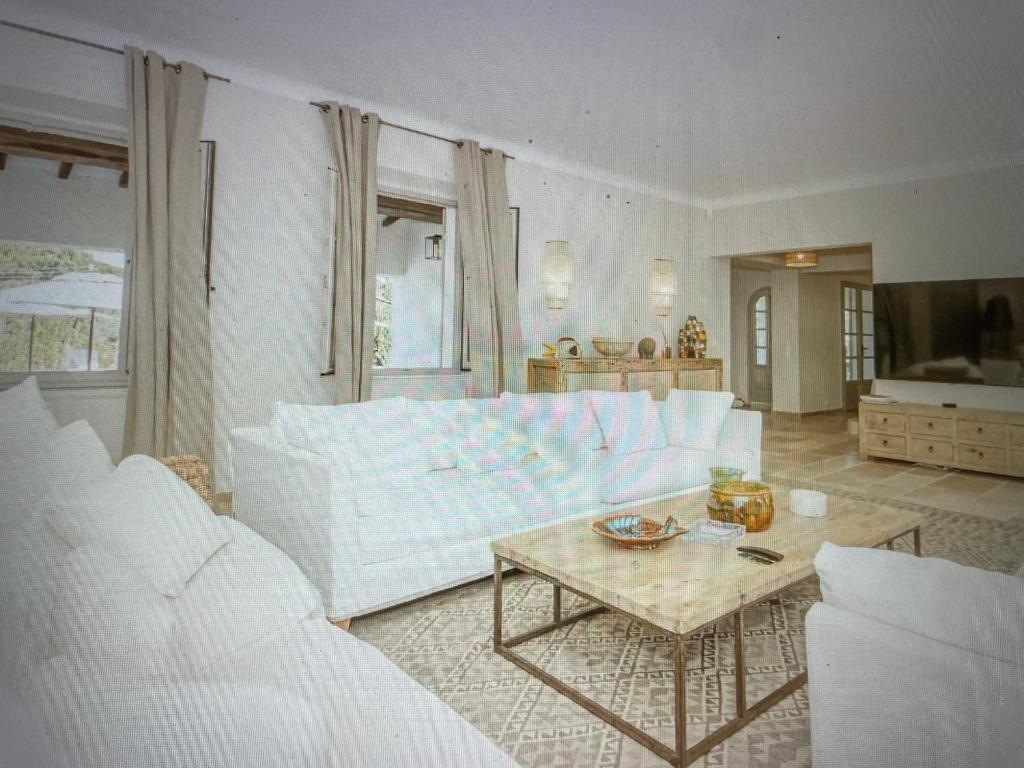 a living room with a white couch and a table at Villa Sunset Bay in Baja Sardinia