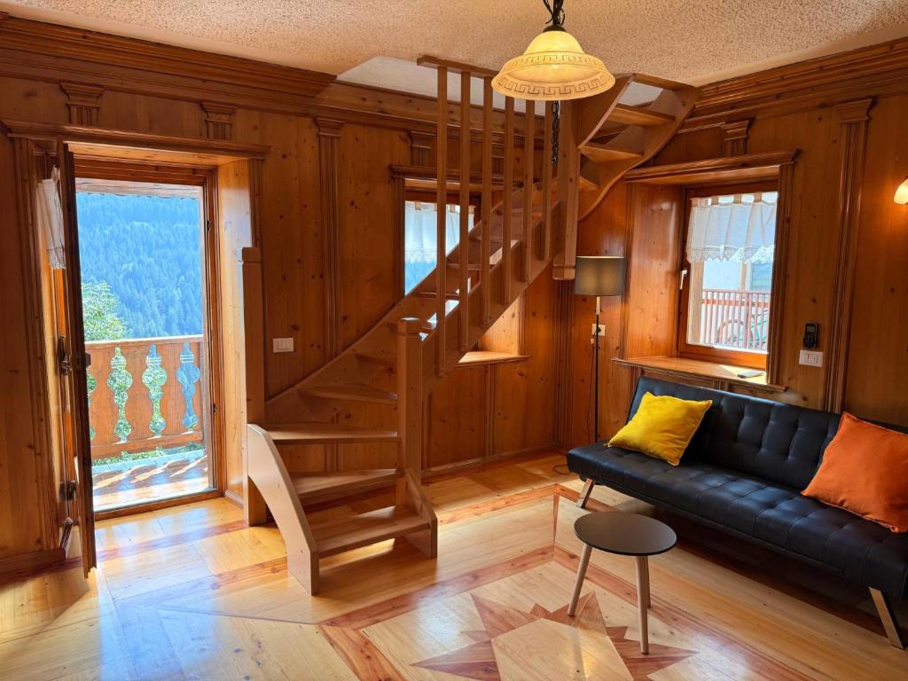 a living room with a spiral staircase and a couch at Appartamento Girasole - Cadore Apartments in Candide