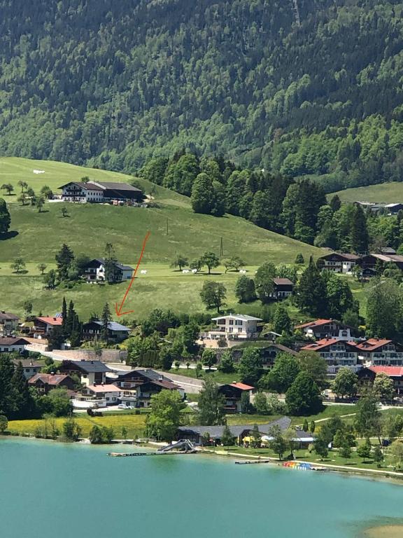 a small town next to a body of water at Villa overlooking Lake Thiersee in Vorderthiersee