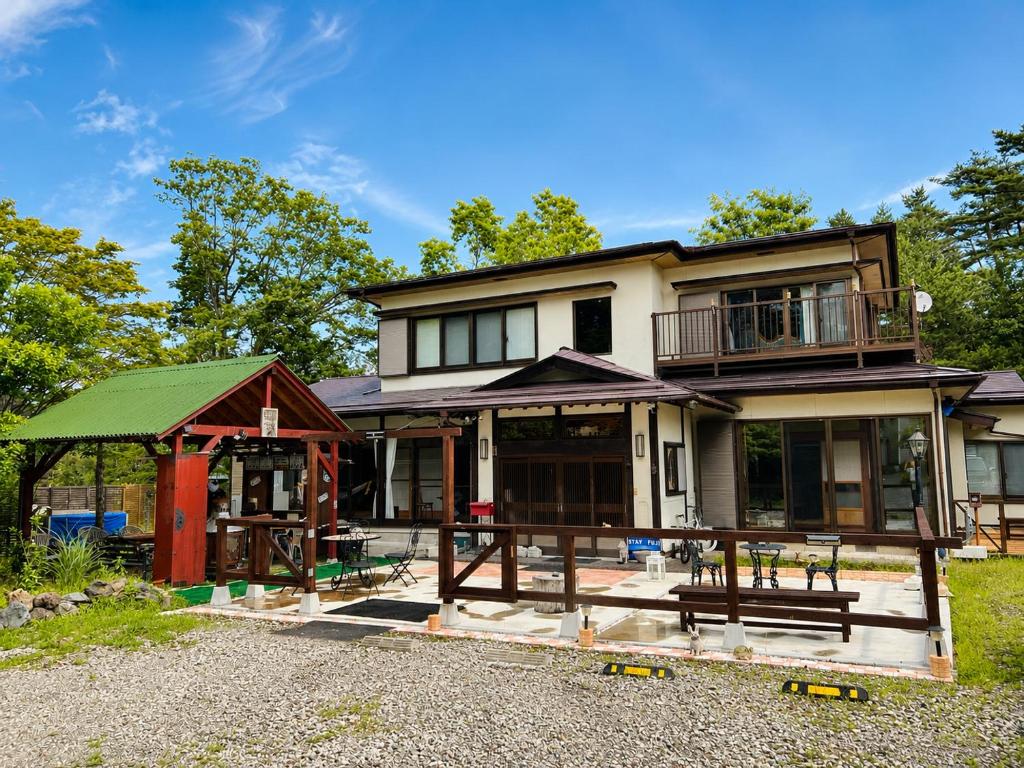 a house with a green roof and a porch at STAY FUJI a in Yamanakako