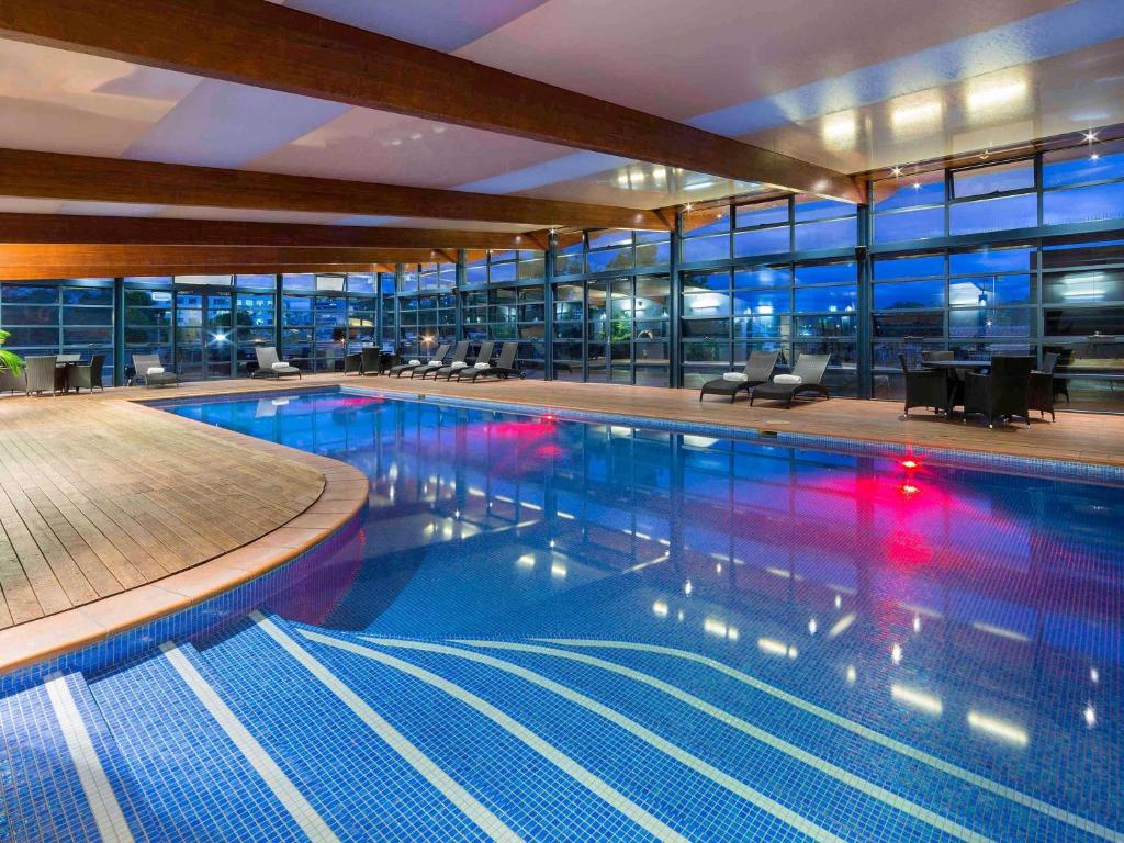 a large swimming pool in a building at Novotel Canberra in Canberra
