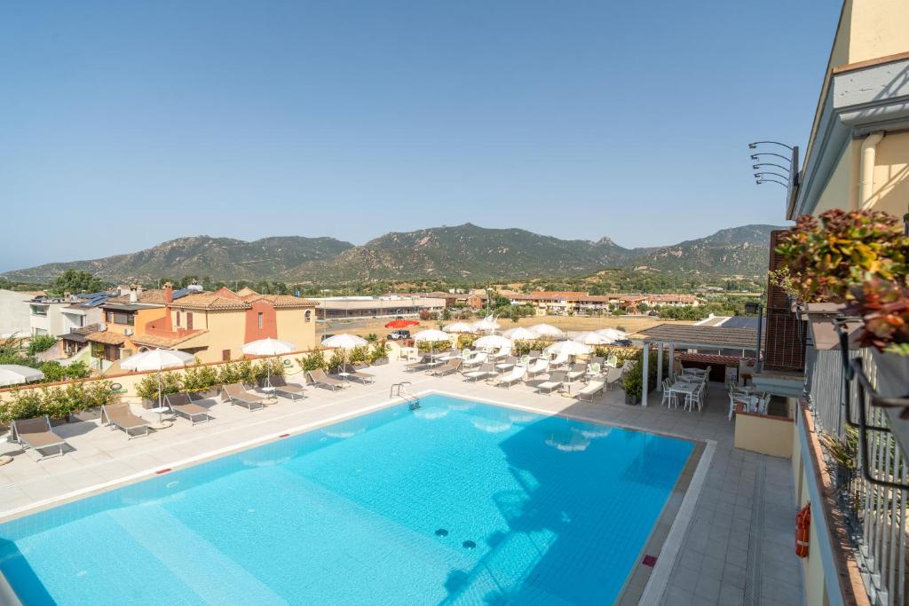 a pool on the balcony of a hotel with chairs and umbrellas at Residence Le Fontane in Villasimius