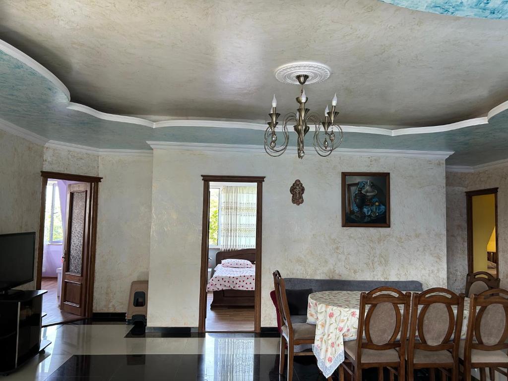 a dining room with a table and a chandelier at Beka's GuestHouse in Gonio