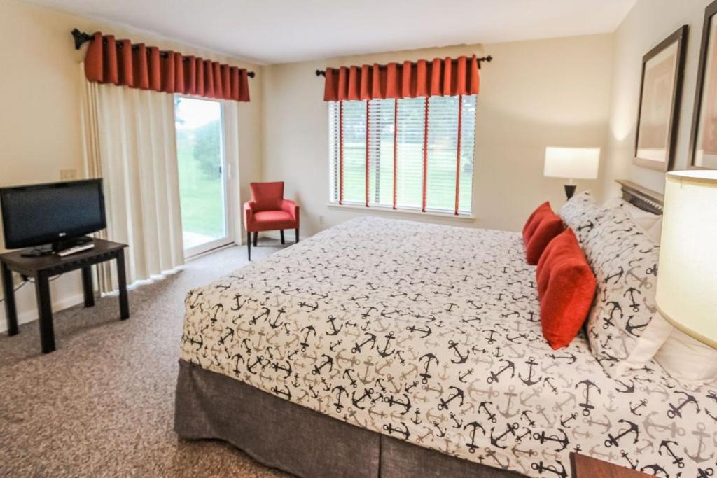 a bedroom with a large bed and a television at Brewster Green Resort in Brewster