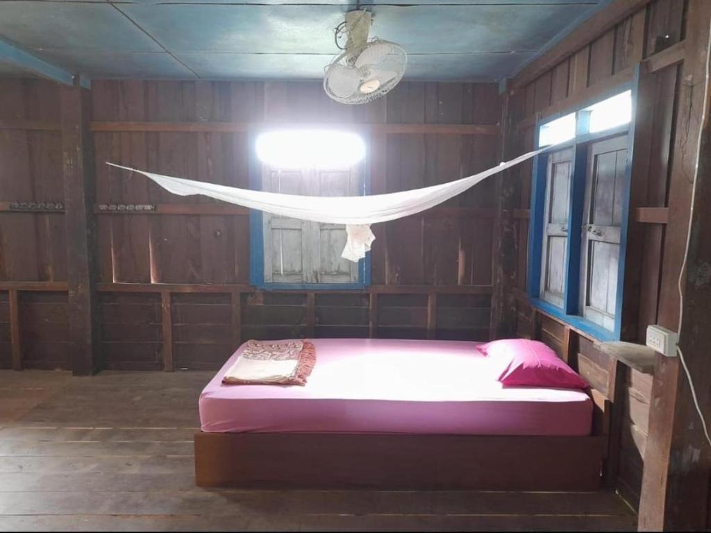 a bedroom with a bed with a net in it at Nature Dormitory in Ban Donsôm Tai