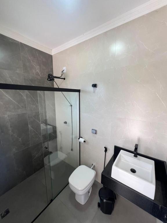 a bathroom with a toilet and a shower and a sink at Alefhouse in Bauru