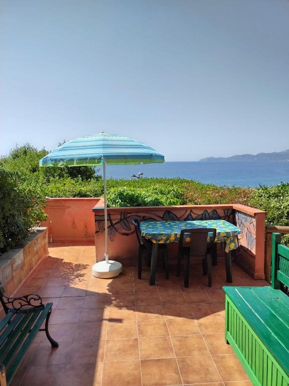 a patio with a table and an umbrella at MAREVIGLIOSO Fronte Mare Sea Front in Magomadas