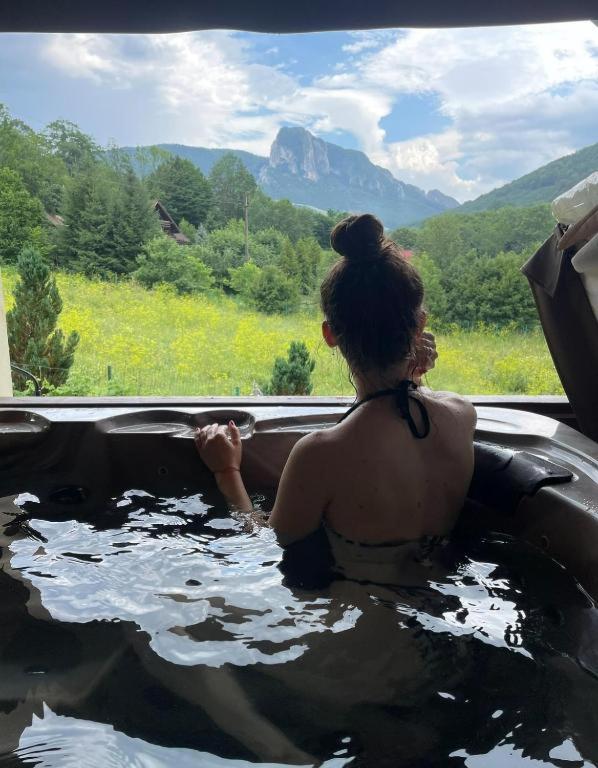 a woman sitting in a bath tub with a view at Vila lui Simion in Rimetea