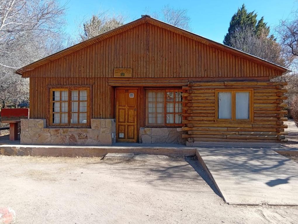 a log cabin with a large door and windows at Cabañas Espacio Prana in Uspallata