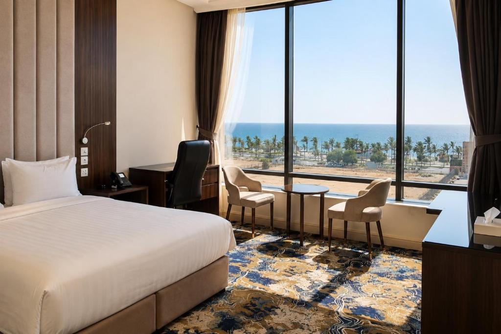 a hotel room with a bed and a large window at المهاجر للشقق المخدومة بالكورنيش in Jeddah