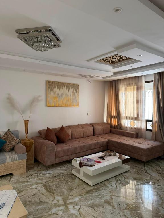 a living room with a brown couch and a table at Lemjid house in Kelibia